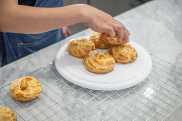 Close up women hand holding Choux Cream put on a display.