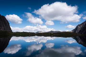 klarer bergsee mit spiegelung in den alpen