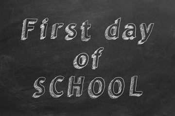 Hand drawing text "First Day of School" on blackboard.