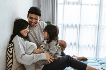 enjoy chatting little girl with mother and father when sitting on a family room