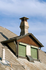 Fototapeta na wymiar Mansard roof and chimney pot of a cottage