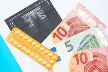 hormonal pills and euro money on the background of the sheet with ultrasound