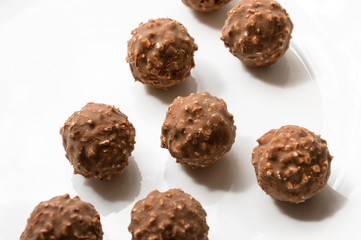 round chocolate candy with nuts on a white plate