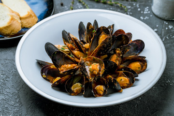 Mussels in tomato sauce on white plate