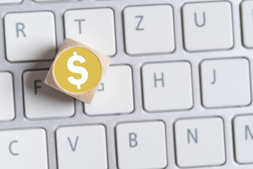 Würfel mit Dollar-Symbol auf Tastatur