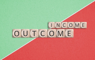 cubes with the word "income" and "outcome" on paper background
