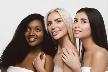 Three different nation girls with diversuty in skin, hair. Caucasian, African american and Asian girls cheerful emotional posing on white background,  lifestyle people concept.