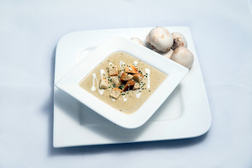 Hero Shot of a Mushroom Soup with bread crumbs, oregano on a minimal white background with a 45 degree angle