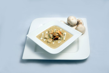 Contrasted Hero Shot of a Mushroom Soup with bread crumbs, oregano on a minimal white background with a 60 degree front facing angle