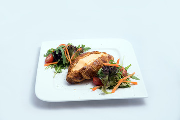 A low contrast image of a breakfast platter with cheese-filled croissant with vegetables- carrot, tomato, lettuce on a minimal white background with a 30 degree angle from front zoomed in perspective