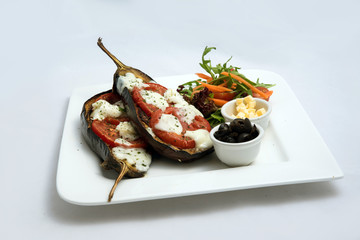 A low contrast warm Hero shot of a main course platter with grilled aubergine with buffalo cheese on a minimal white background with a 45 degree angle from diagonal perspective.