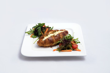 A low contrast Hero shot of a breakfast platter with cheese and zaatar filled croissant with vegetables with a 30 degree angle from front perspective