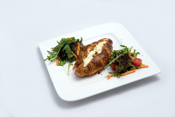 A low contrast Hero shot of a breakfast platter with cheese and zaatar filled croissant with vegetables with a 30 degree angle from front perspective