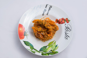 A low contrast Hero shot of chicken curry with pasta noodles in a plate with minimal white background with 60 degree angle from front perspective