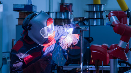 Welder in the factory,Worker with protective mask welding metal industry.