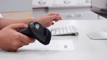 Female Hands Reading barcode with scanner and typing on keyboard