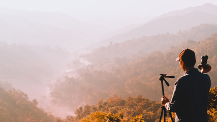 web banner and panorama of earth day and environment care travel concept from photographer man during take photo beautiful landscape of tropical forest with haze with soft focus of layer mountain