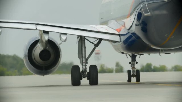 An airplane riding on the airport field - working turbine - warm air from the turbine