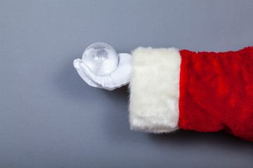 Weihnachtsmann hält Erde als Glaskugel in Hand