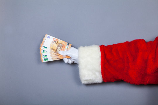 Weihnachtsmann h&auml;lt 50-Euro-Scheine in Hand