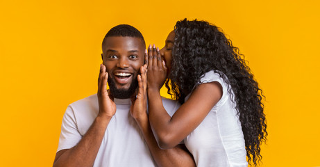 Black girl sharing secret with her boyfriend