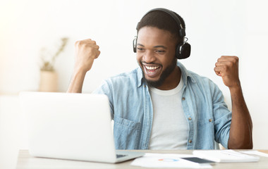 Black male freelancer celebrating successful completing online interview