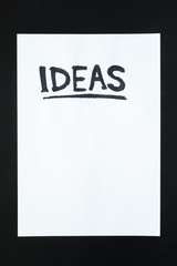 Word "ideas" handwritten on empty paper sheet. Sign, concept of new beginning or planning, abstract illustrative image