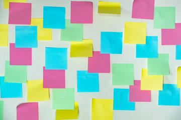 Fototapeta na wymiar Sticky paper notes on a planning board. Planning, brainstorm, diversity or fresh ideas concept - pattern of empty multicolored paper notes