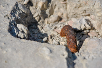 rusty hook on a white rock