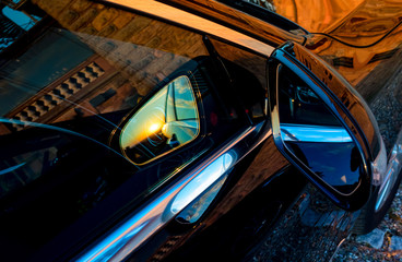 Luxury car mirror with sunset reflection - obrazy, fototapety, plakaty