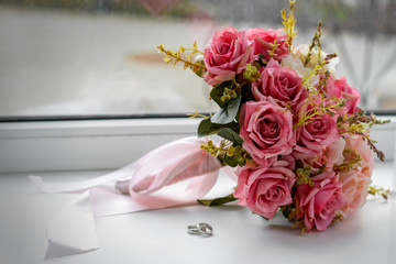 Beautiful wedding still life with a bouquet and rings