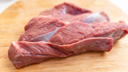 Fresh slice of beef close-up. Preparation for cooking red meat with spice and tomato.