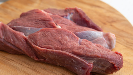 Fresh slice of beef close-up. Preparation for cooking red meat with spice and tomato.