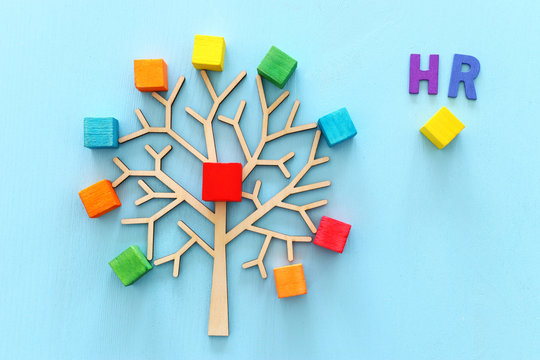 Business image of wooden tree with colorful cubes over blue table, human resources and management concept