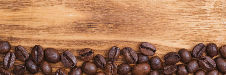 Coffee bean. The background of roasted coffee beans is brown on wooden boards. layout. Flat lay.