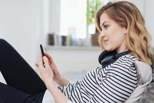 Young woman selecting tunes on her mobile phone