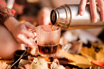  Hot tea from a thermos is poured into a cup