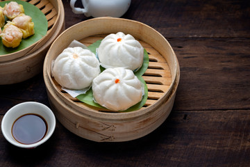 Steamed Dumplings Dim Sum in bamboo basket steamer chiness style at Thai restaurant, steamed stuff bun on wood background