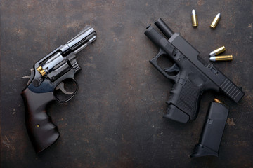 Gun with ammunition on iron dark background.