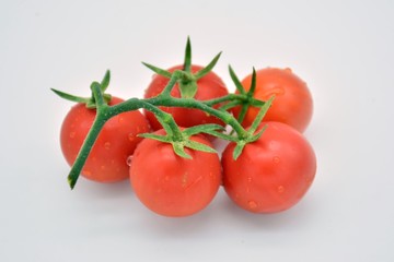 Rama de tomates pequeños rojos y frescos
