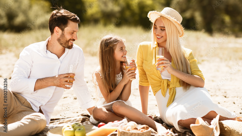 Wall mural Happy family having picnic, resting in nature