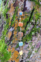 Handmade bracelet from square ceramic beads hanging on the tree, the composition with women's jewelry, fashion photography.