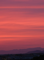 Amazing cloudy sky background. Bright magenta, purple colors sunset over the city. Nature landscape, realistic scenery. The red sky looked like smoke and fire. Beautiful sunset view. Happy vacation.