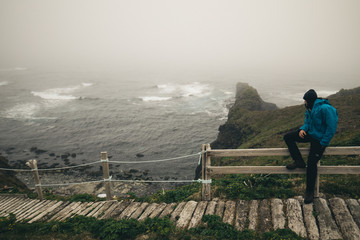 man looking on stormy sea at horn at hornstrandir natural reserve westfjords iceland