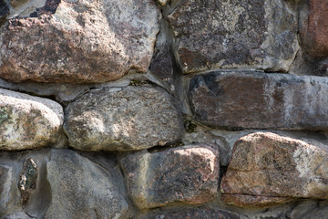 The texture of the old stone wall of large cobblestones