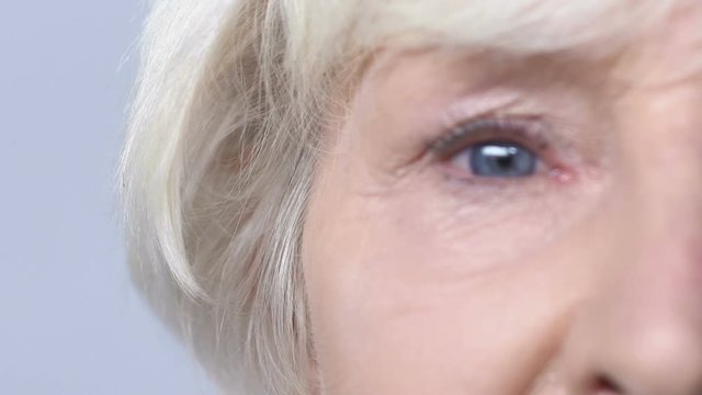 Elderly woman looking into camera, problems with eyes, blurry vision, cataracts