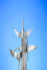Flying metal cranes sculpture in the blue sky