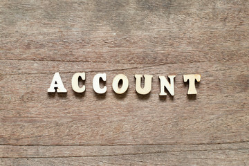 Letter block in word account on wood background