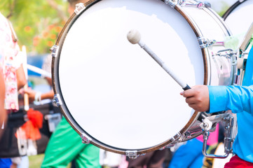 Drummer in blue uniforms a Marching Band. Drummer plays big drum in parade