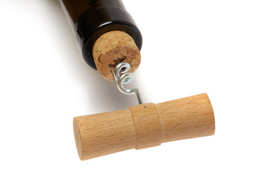 Old fashioned wooden corkscrew in a cork in a wine bottle isolated on white background.